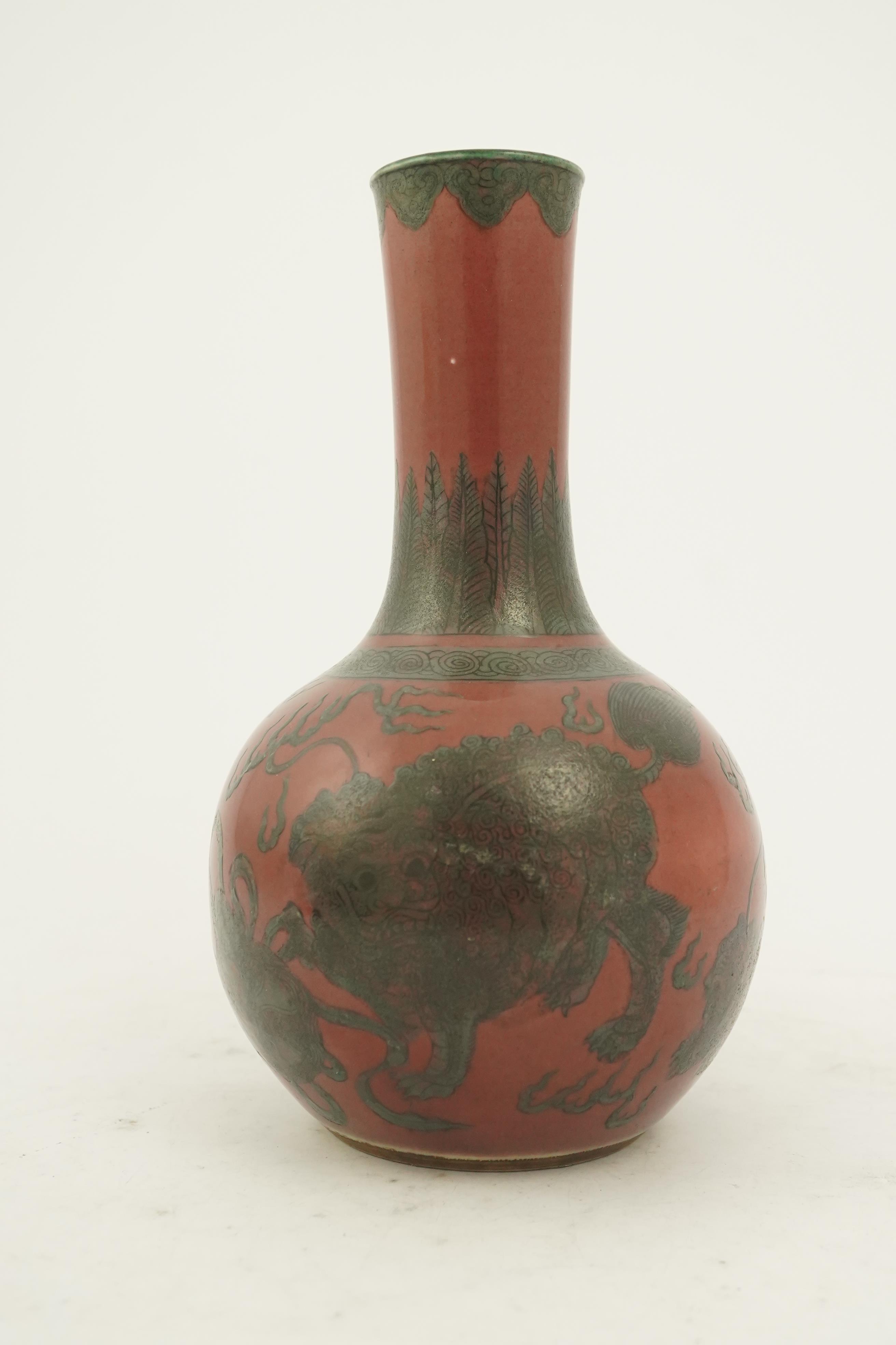 A Chinese green enamelled sang de boeuf ground 'lion' bottle vase, probably 18th century